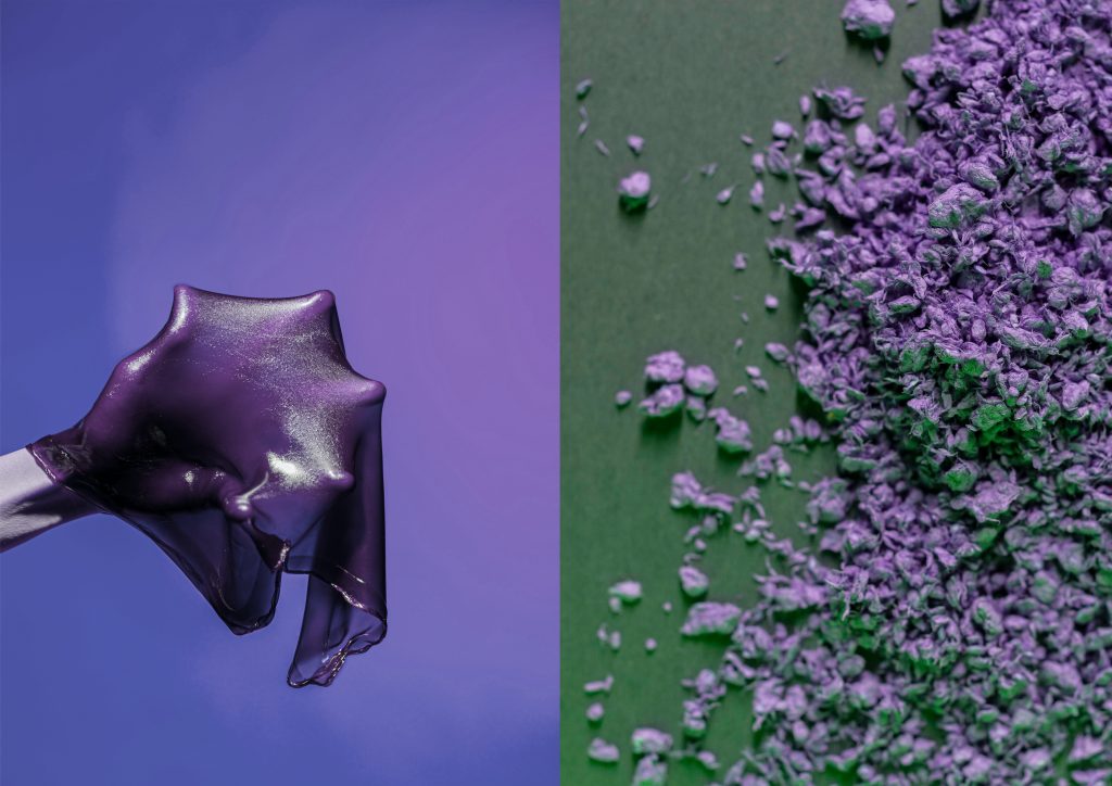 On the left: Hand holding a violet bioslime. On the right violet cellulose crumbs spread on a green paper.