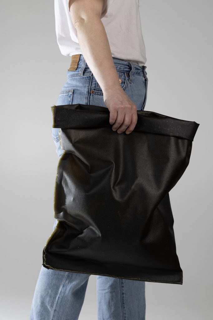Person holding an algae Bag by Anna van der Lei & Elizaveta Lingonberg. Photo Esa Kapila.